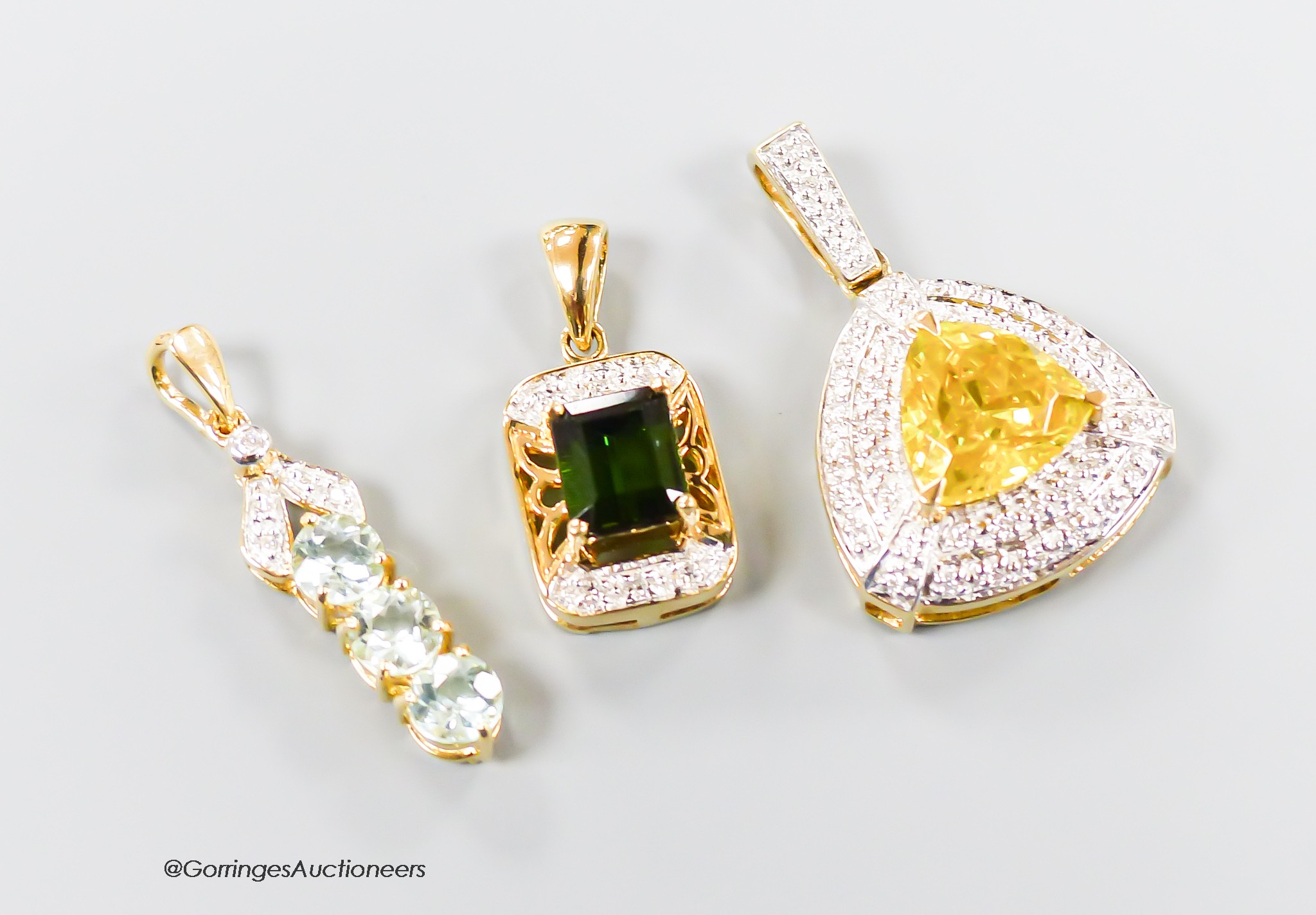 Three assorted modern 18ct gold and gem set pendants, including sphalerite and diamond, overall 27mm, green tourmaline and diamond and three stone tourmaline and diamond chip line pendant, gross 10.5 grams.